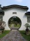 A_view_through_the_archway_in_the_Bonsai_Garden_up_along_the_paved_path.jpg