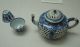 A_blue-and-white_teapot_with_pierced_flower_design_and_two_cups_from_the_Qing_Dynasty_in_the_reign_of_Kangxi.jpg